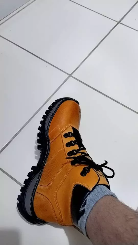 Homem vestindo botina, vista lateral
